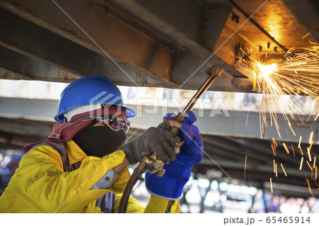 Worker is cutting manually old metal construction 65465914