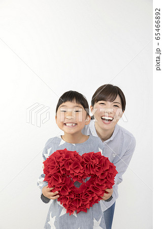 ハートを持つ子供と寄り添うお母さん ハートを持つ子供と寄り添うお母さん 65466892