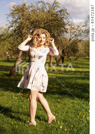 Smiling summer woman with straw hat in park 65472387