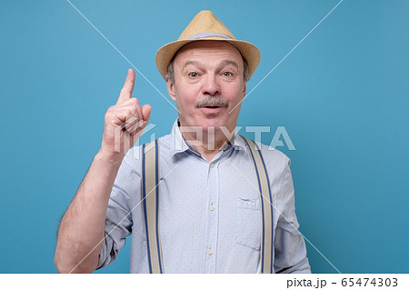 Senior hispanic man in summer hat looking up and 65474303