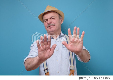 Attractive mature man in summer hat showing 65474305
