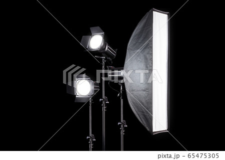 Photo studio lighting stands with flash and softbox isolated on the black. Photo studio lighting stands with flash and softbox isolated on the black. 65475305