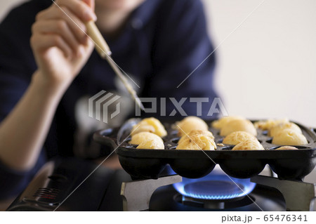 ピックを持ってたこ焼きを焼く女性 ピックを持ってたこ焼きを焼く女性 65476341