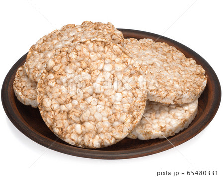 Puffed rice bread in a plate isolated on white background, diet crispy round rice waffles 65480331