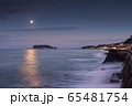 七里ガ浜駐車場から眺める月の光を浴びて輝く海面と江ノ島、朝焼けの空 65481754