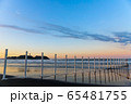 夏の風物詩の海岸の白杭越しに眺める朝焼けに輝く空の下の江ノ島 65481755
