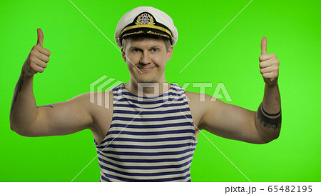 Young sailor man thumbs up, looking at camera. Seaman guy in sailor's vest 65482195