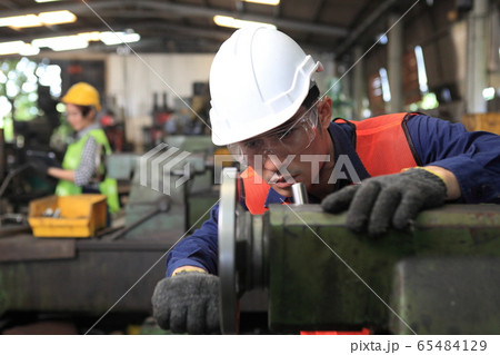 Factory Engineer operating big machine cut off Factory Engineer operating big machine cut off 65484129