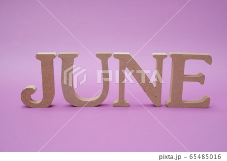 紫色の背景に置かれた「JUNE」のアルファベットブロック 65485016