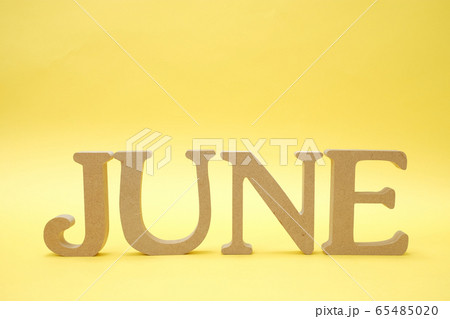 黄色の背景に置かれた「JUNE」のアルファベットブロック 65485020