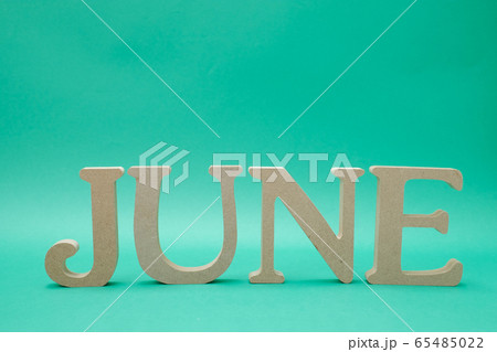 緑色の背景に置かれた「JUNE」のアルファベットブロック 65485022