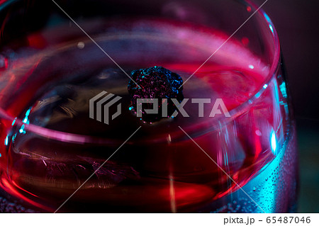 Close up of alcoholic cocktail, beverage, drink in multicolored neon light 65487046