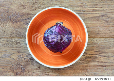 purple head of red cabbage on a orange plate on a 65494041