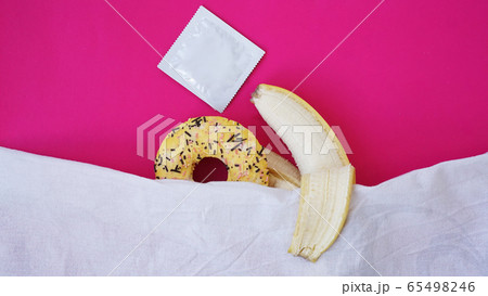 Sweet donut and banana on pink color background. Erotic concept Sweet donut and banana on pink color background. Erotic concept 65498246