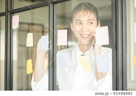 若い きれい 女性 会社員 笑顔 付箋 窓 貼る メモ 携帯 電話 確認 人物 素材 若い きれい 女性 会社員 笑顔 付箋 窓 貼る メモ 携帯 電話 確認 人物 素材 65498985