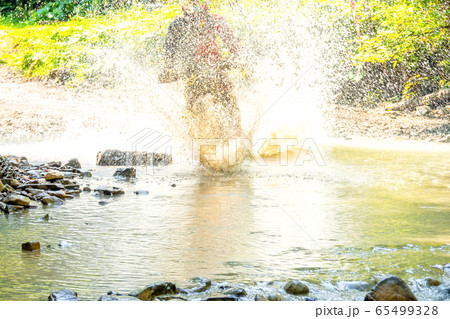 Spray From a Motorcycle in a Sunny Summer Forest 65499328