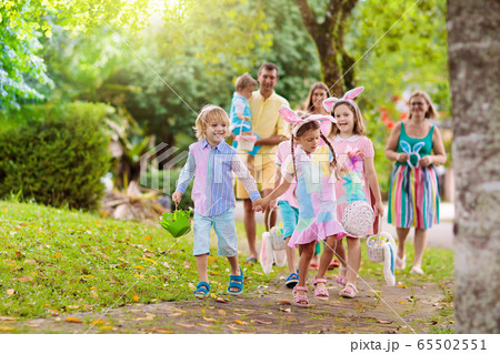 Family with kids on Easter egg hunt Family with kids on Easter egg hunt 65502551