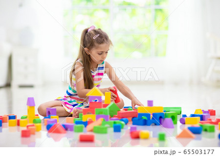Child playing with toy blocks. Toys for kids. 65503177
