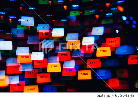 DJ mixer in a nightclub with a background of glowing lights from buttons DJ mixer in a nightclub with a background of glowing lights from buttons 65504348