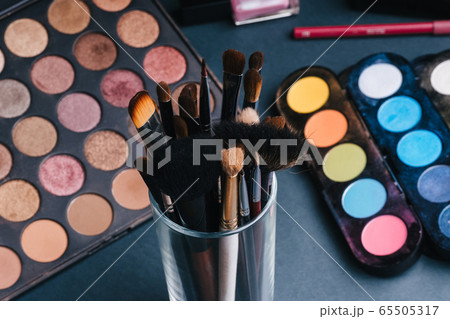set of makeup brushes on the background of a professional palette with eye shadows set of makeup brushes on the background of a professional palette with eye shadows 65505317
