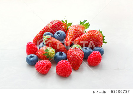 small fruits raspberries strawberries and blueberries close-up on a light background small fruits raspberries strawberries and blueberries close-up on a light background 65506757