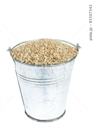 Full bucket of sesame seeds on a white background. 65507342