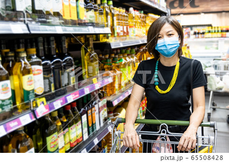 Asian woman shopping groceries in supermarket with protective face mask as new normal  65508428