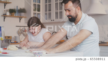 Father and daughter preparing cookies together 65508911