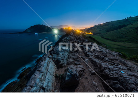 Night view of the cliff with low tide and the light of the full moon in Zumaia 65510071