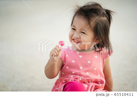 Little child girl enjoy eating lollipop candy, kid Little child girl enjoy eating lollipop candy, kid 65510411