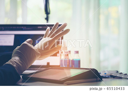 Doctor putting on white sterilized surgical gloves 65510433
