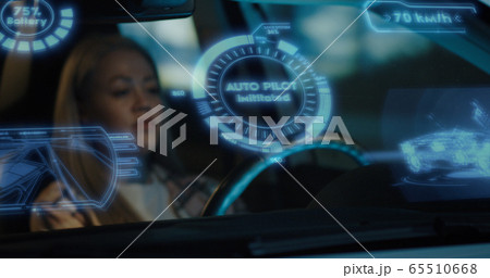 Woman engaging self driving mode in car Woman engaging self driving mode in car 65510668