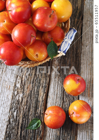 Yellow and red large plums in wicker basket Yellow and red large plums in wicker basket 65511957