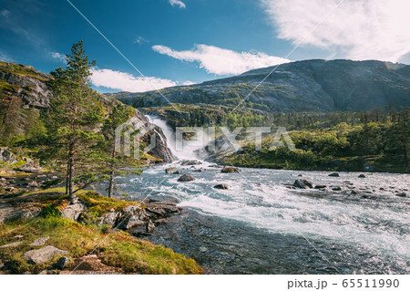 Kinsarvik, Hordaland, Norway. Waterfall Nykkjesoyfossen In Hardangervidda Mountain Plateau. Summer Sunny Day. Height Of 49 m. Famous Norwegian Landmark And Popular Destination 65511990