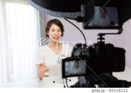 一眼レフカメラで動画を撮影する女性 65516112