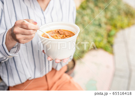 テイクアウトのカレーを食べるビジネスウーマン 65516418