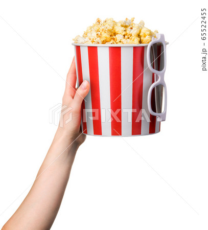 Woman hand holding striped bucket with popcorn and 65522455