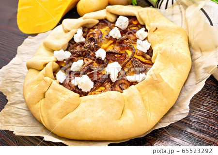 Pie with pumpkin and onions on parchment Pie with pumpkin and onions on parchment 65523292