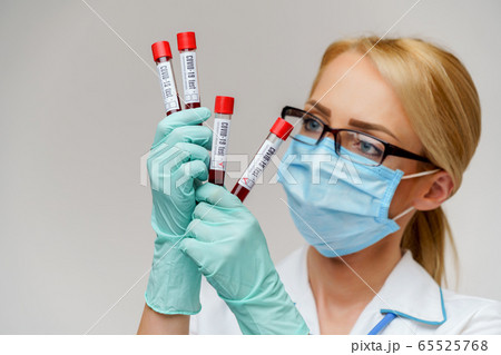 medical doctor nurse woman wearing protective mask and gloves - holding virus blood test tube 65525768