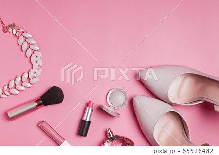 Flat lay of female fashion accessories, shoes and makeup products pink color background. 65526482
