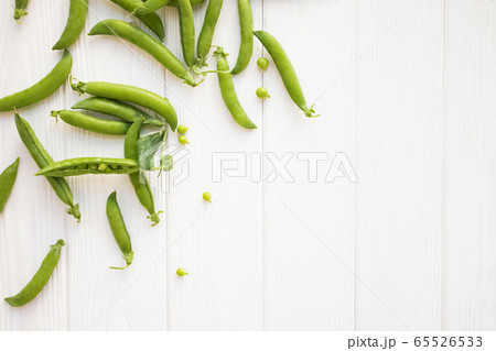 Green peas pods and seeds on white table top view. 65526533