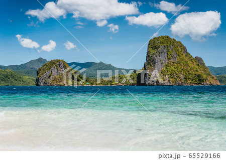 El Nido, Philippines. Crystal clear blue water lagoon and private Malapacao island in background 65529166
