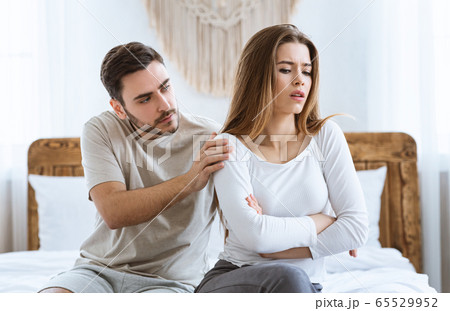 Man consoles an offended woman in interior at bedroom. Man consoles an offended woman in interior at bedroom. 65529952