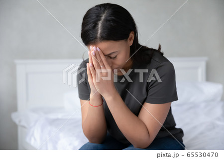Devout African woman prays in morning sitting on bed Devout African woman prays in morning sitting on bed 65530470