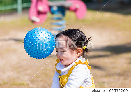 公園でボール遊びする可愛い女の子の写真素材