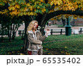 Young blond girl with closed eyes staying near 65535402