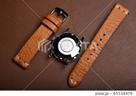 Vintage wristwatch on a brown leather background. Classic watch straps. Vintage wristwatch on a brown leather background. Classic watch straps. 65538976