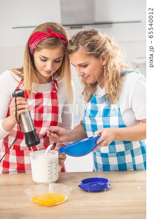 Blonde mother helps daughter with baking in the Blonde mother helps daughter with baking in the 65540012