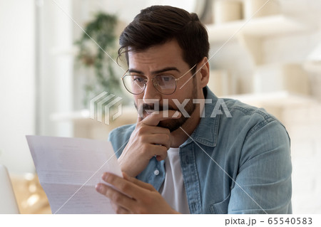 Frustrated man read bad news in paper post letter Frustrated man read bad news in paper post letter 65540583