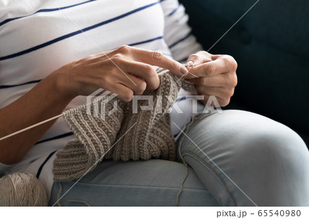 Close up middle aged mature woman knitting handmade warm sweater. 65540980